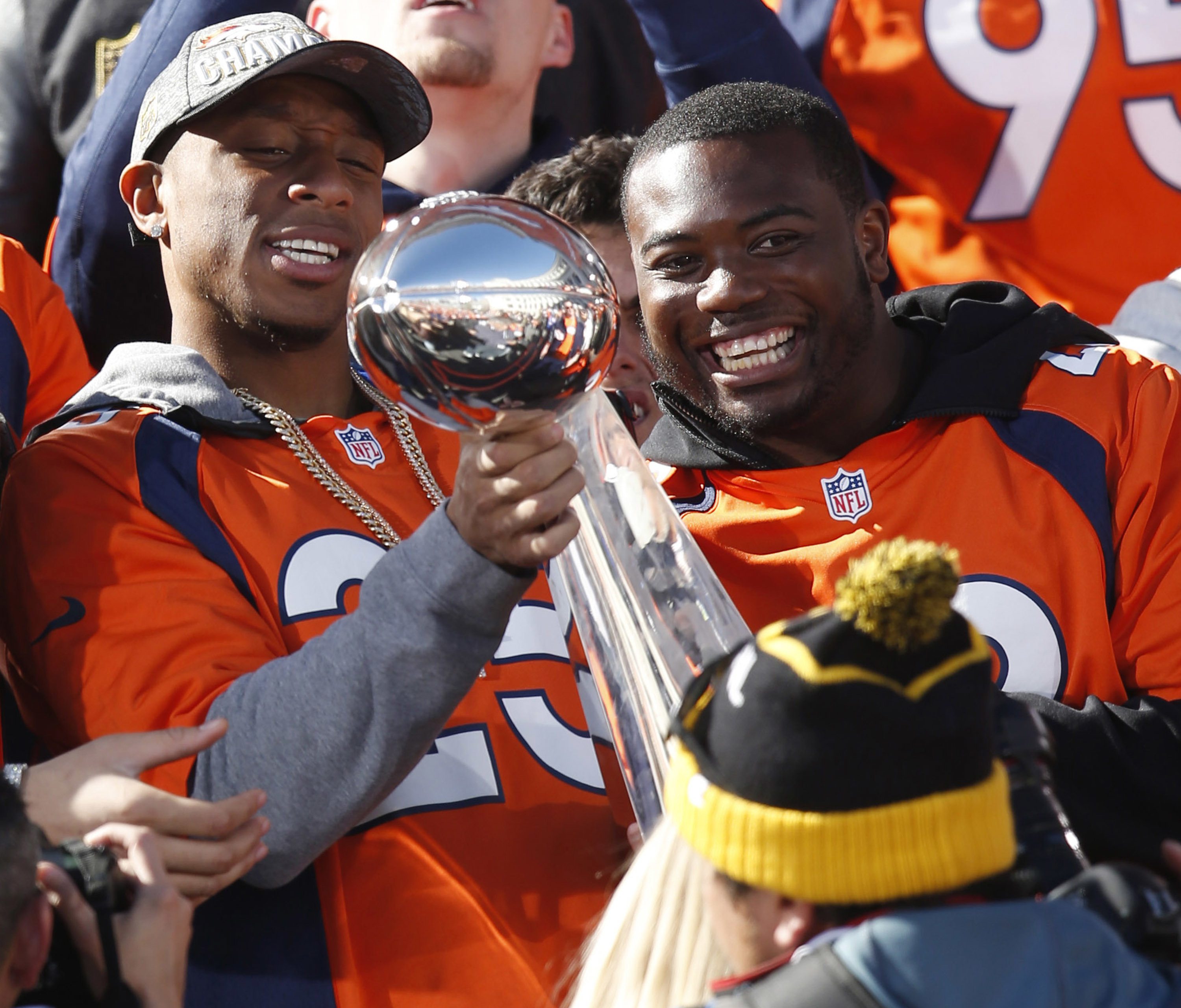 Denver Broncos cornerback Chris Harris, left, holds the Lombardi Trophy as running back C.J. Anderson looks on at a rally following a parade through downtown Tuesday, Feb. 9, 2016 in Denver. The Broncos will keep Anderson on the roster after matching Miami's four-year, $18-million offer to the running back who scored the Broncos' only offensive touchdown in Denver's victory over Carolina in Super Bowl 50.