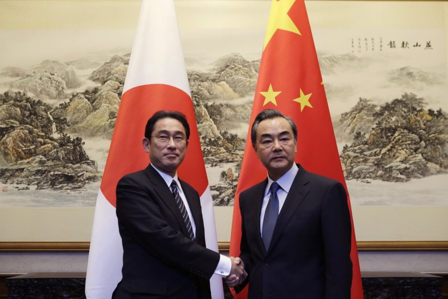 Japanese Foreign Minister Fumio Kishida, left, shakes hands with China&#039;s Foreign Minister Wang Yi on Saturday in Beijing, China, Saturday, April 30, 2016.