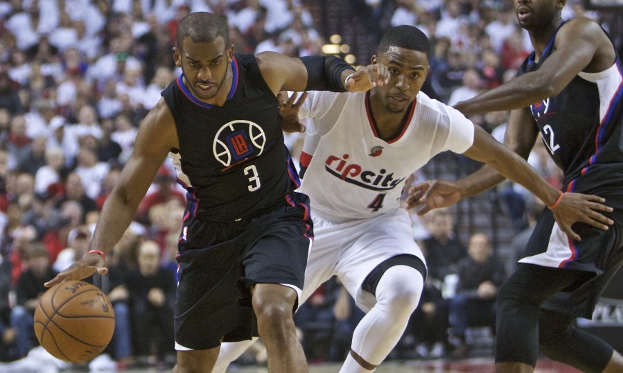 Los Angeles Clippers guard Chris Paul, left, dribbles past Portland Trail Blazers forward Maurice Harkless, right, during the first half of Game 4 of an NBA basketball first-round playoff series Monday, April 25, 2016, in Portland, Ore.