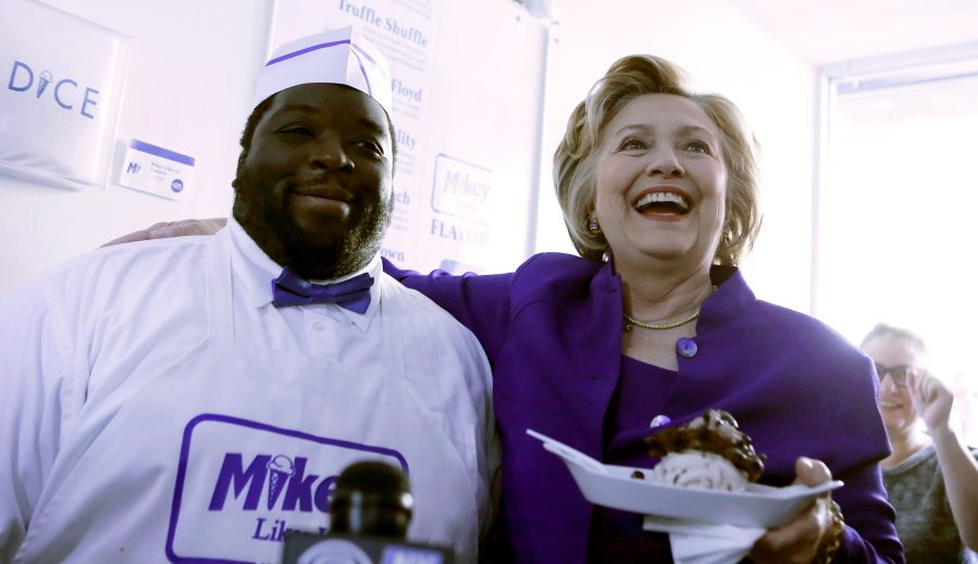 Democratic presidential candidate Hillary Clinton smiles with Mikey Cole, owner of Mikey Likes It Ice Cream during a campaign stop Monday at his store in the East Village in Manhattan, a day ahead of the New York primary.