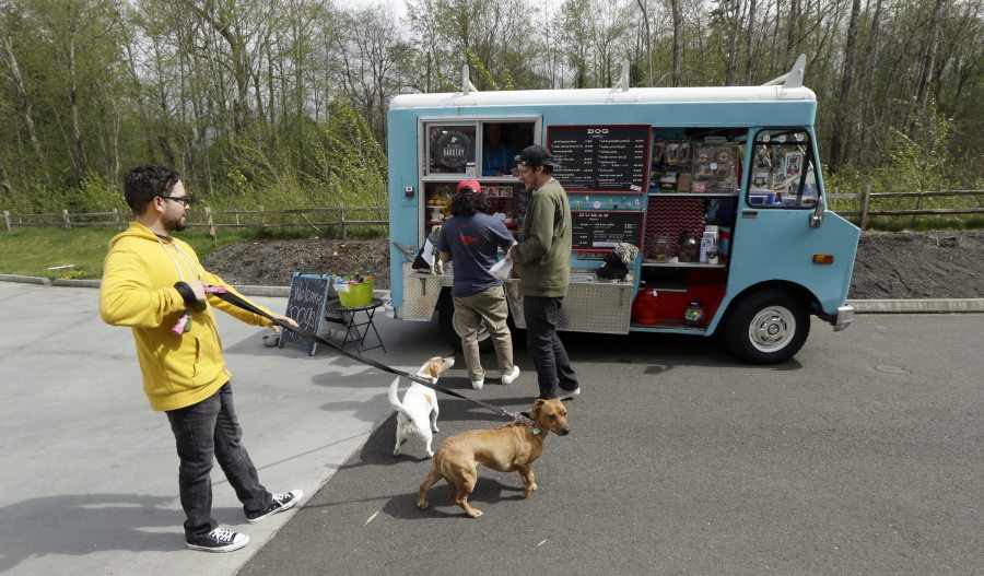 Dog owners line up at a food truck specializing in treats for their four-legged friends during the lunch hour April 5 at the headquarters for the clothing and skateboard retailer Zumiez in Lynnwood.