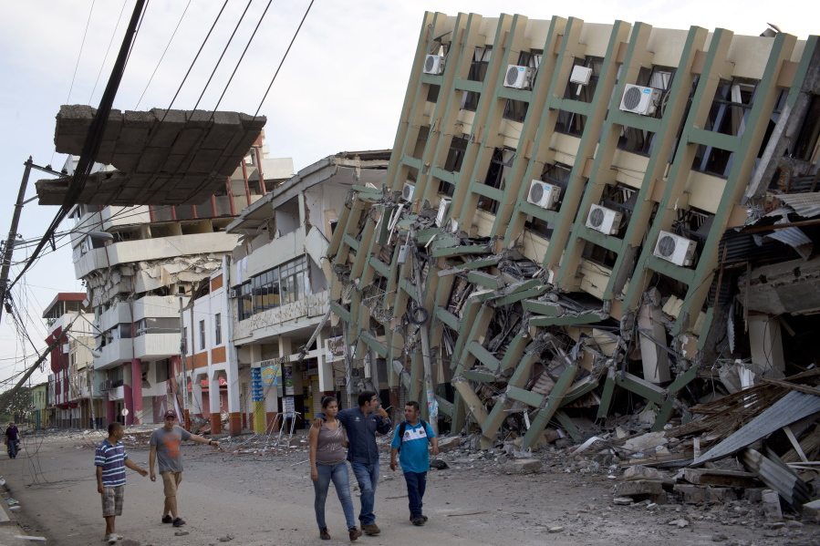 Residents walk Monday past a row of buildings felled by Saturday night&#039;s 7.8-magnitude earthquake in Portoviejo, Ecuador. The quake left a trail of ruin along Ecuador&#039;s normally placid Pacific Ocean coast.