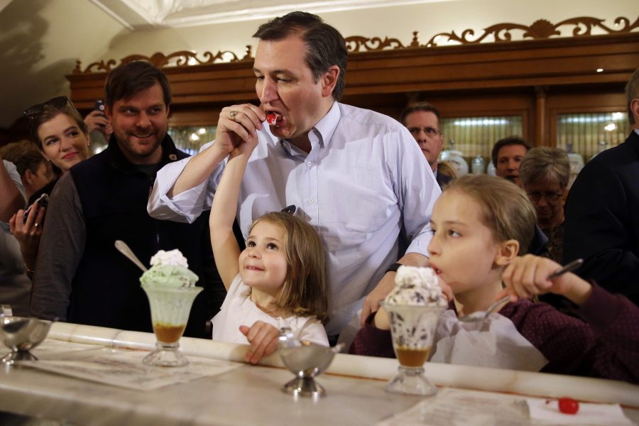 Republican presidential hopeful Sen. Ted Cruz eats a cherry from daughter Catherine&#039;s sundae as Caroline, right, enjoys her ice cream during a campaign stop at Zaharakos Ice Cream Parlor in Columbus, Ind., on Monday.
