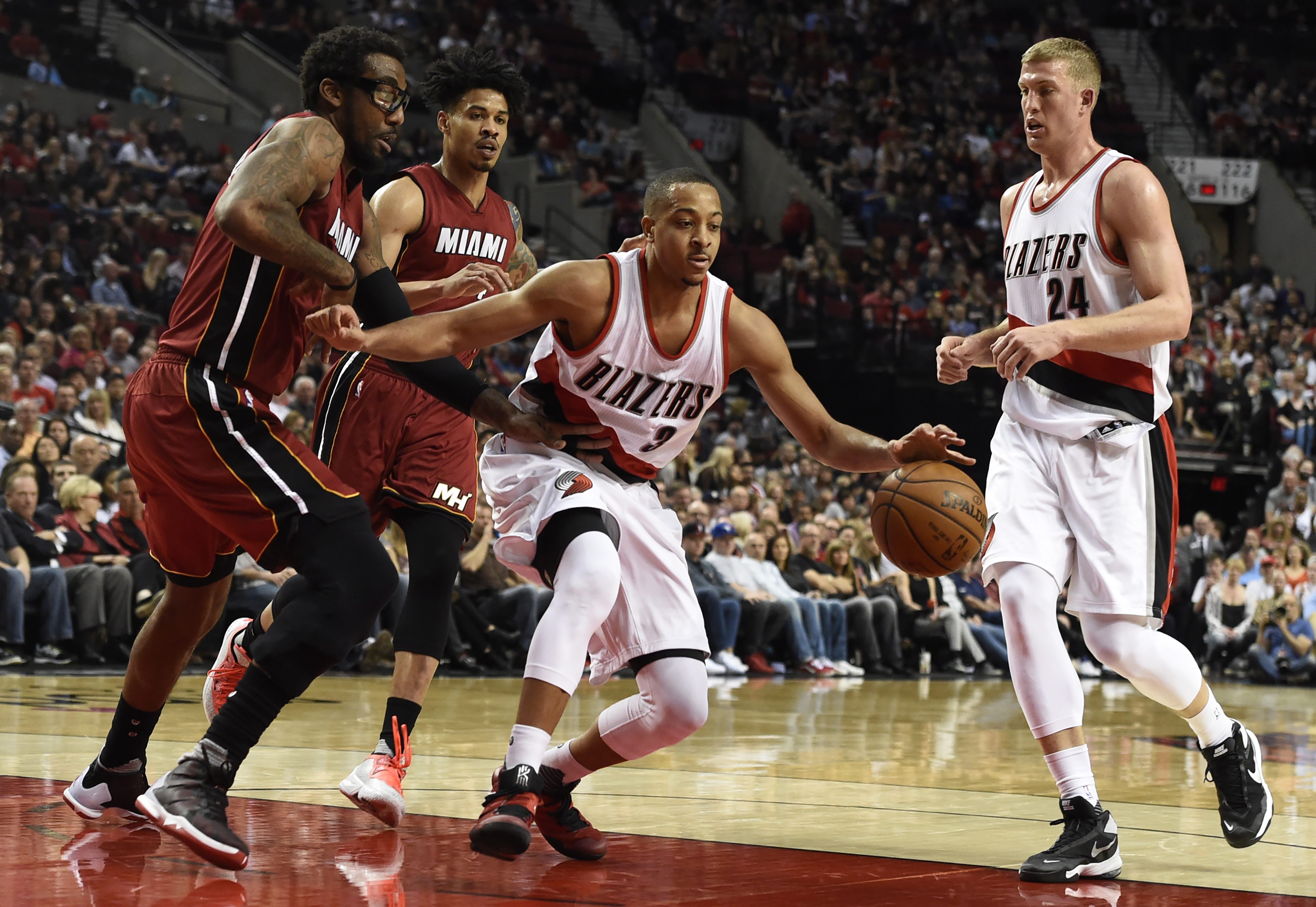 Portland Trail Blazers guard C.J. McCollum (3) tries to dribble the ball past Miami Heat forward Amare Stoudemire and guard Gerald Green (14) as Trail Blazers center Mason Plumlee (24) closes in during the second half of an NBA basketball game in Portland, Ore., Saturday April 2, 2016. The Blazers won 110-93.