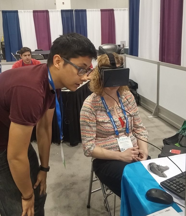 Lester Knight, left, a technology specialist with the Arapahoe County, Colo., library system, helps Illinois library employee Heather Norbors try out an Oculus Rift, a virtual reality headset, Thursday at the Public Library Association&#039;s annual conference in Denver.