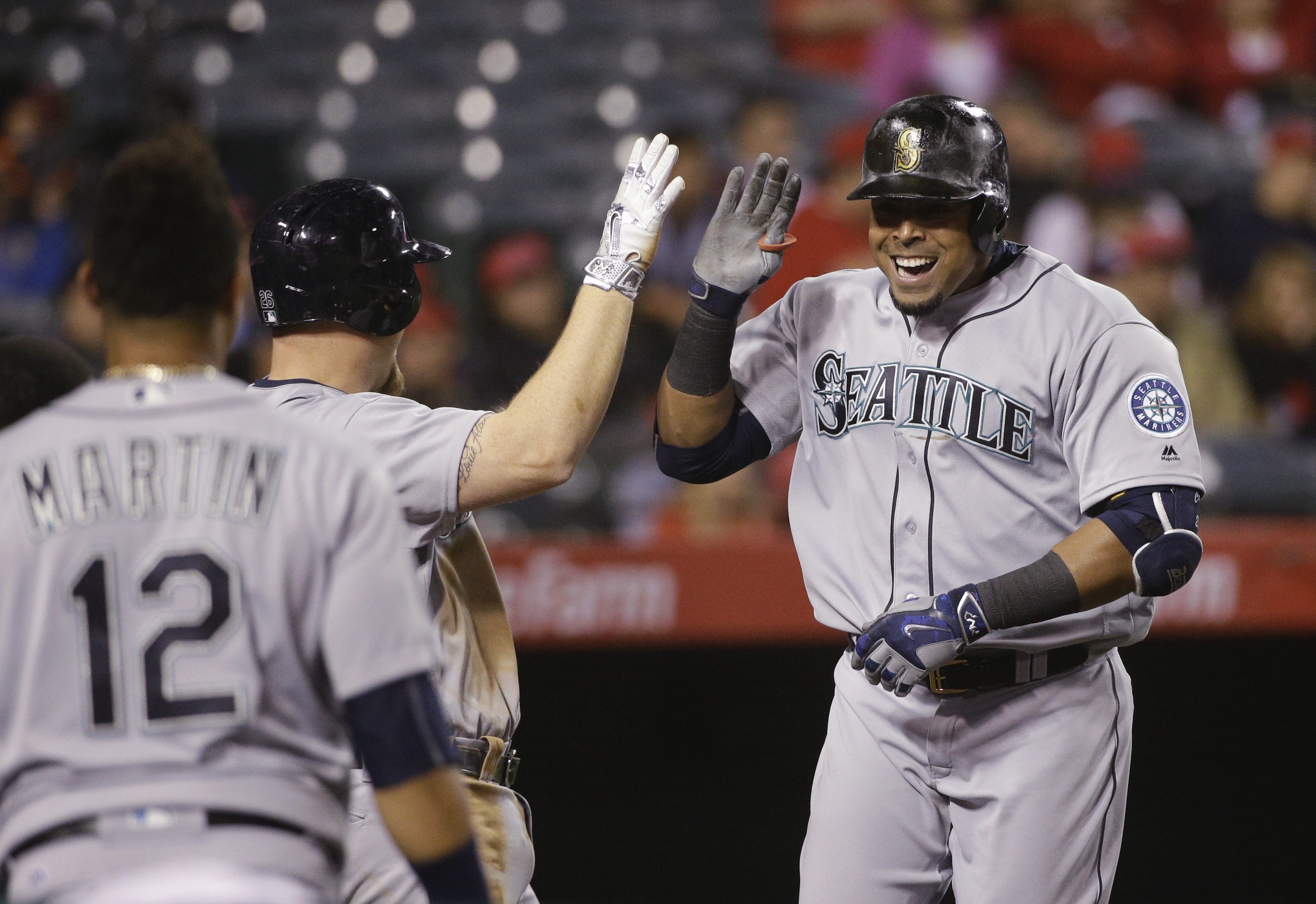 Seattle Mariners' Nelson Cruz, right, celebrates his two-run home run with Adam Lind during the 10th inning of a baseball game against the Los Angeles Angels, Friday, April 22, 2016, in Anaheim, Calif. (AP Photo/Jae C.