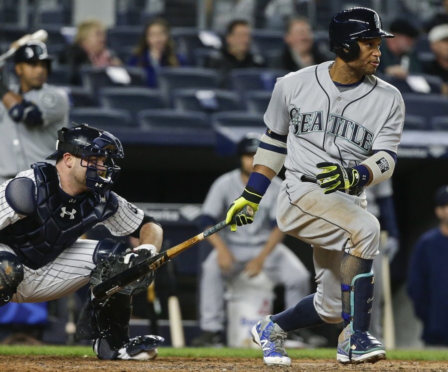 Seattle Mariners&#039; Robinson Cano follows through on an RBI single during the fourth inning of a baseball game as New York Yankees catcher Brian McCann watches, Friday, April 15, 2016, in New York.