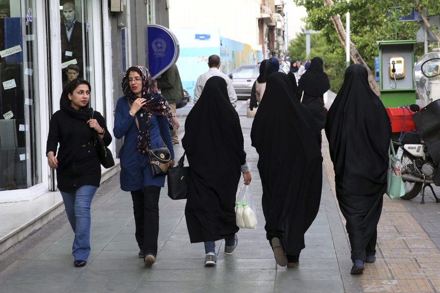 Iranian women make their way along a sidewalk in downtown Tehran, Iran, Tuesday, April 26, 2016. Tehran police chief Gen. Hossein Sajedinia recently announced his department had deployed 7,000 male and female officers for a new plainclothes division _ the largest such undercover assignment in memory. Critics fear the unit?s main focus will be enforcing the government-mandated Islamic dress code, which requires women be modestly covered from head to toe.