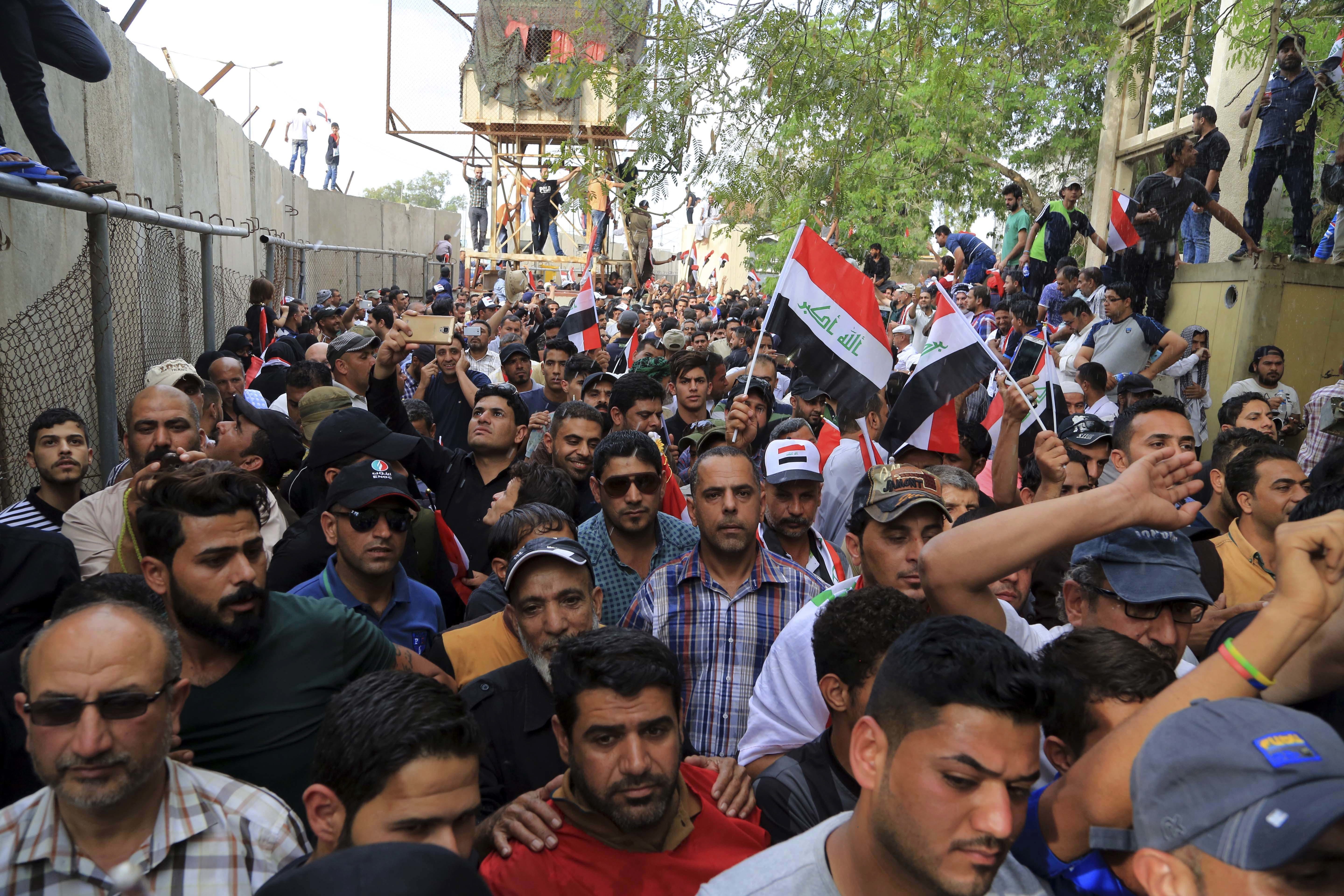 Supporters of Shiite cleric Muqtada al-Sadr storm the Green Zone, Saturday, April 30, 2016. Dozens of protesters climbed over the blast walls and could be seen storming the Parliament building, carrying Iraqi flags and chanting against the government.