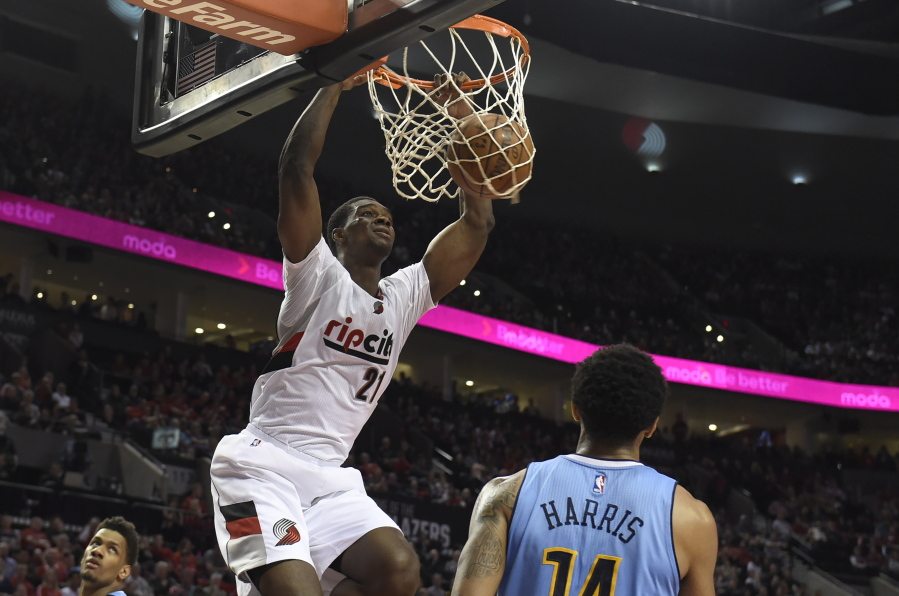 Portland Trail Blazers forward Noah Vonleh (21) dunks in front of Denver Nuggets guard Gary Harris (14) during the second half of an NBA basketball game in Portland, Ore., Wednesday, April 13, 2016. The Blazers won 107-99.