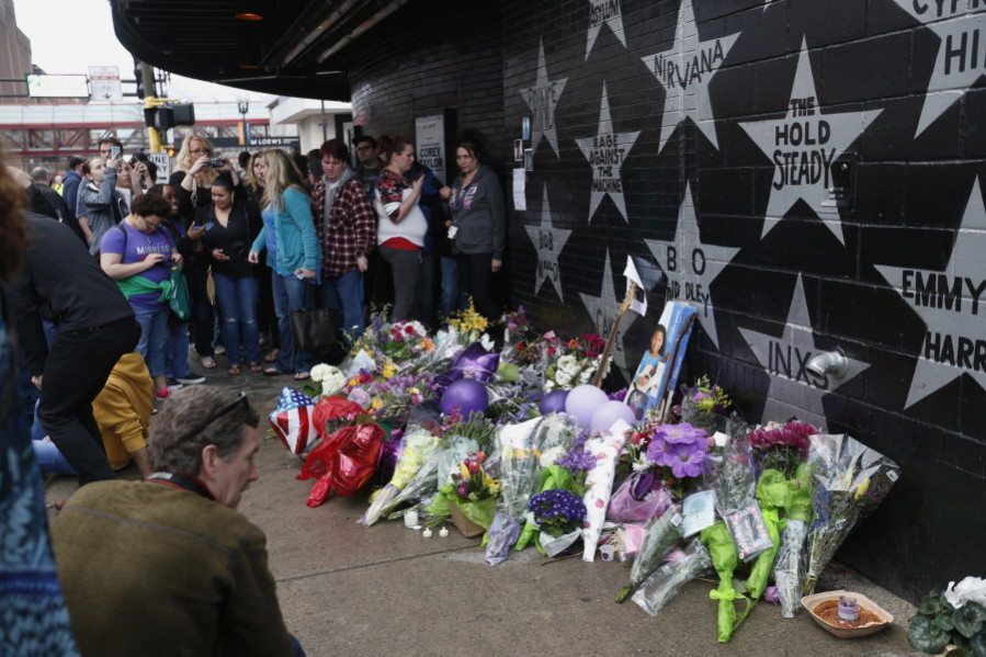 People gather at a memorial created below Prince&#039;s star, center top, adorning the wall of First Avenue, where the pop super star Prince often performed, in Minneapolis on Thursday. Prince was found dead at his home on Thursday in suburban Minneapolis, according to his publicist. He was 57.
