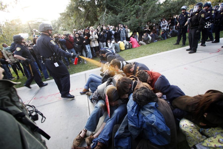 University of California, Davis Police Lt. John Pike uses pepper spray to move Occupy UC Davis protesters in 2011. The school paid at least $175,000 to clean up its online reputation regarding the incident.