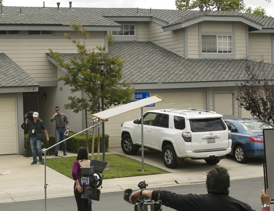 Members of the media stand outside the home of Syed Raheel Farook after the FBI served a warrant at the property Thursday in Corona, Calif.