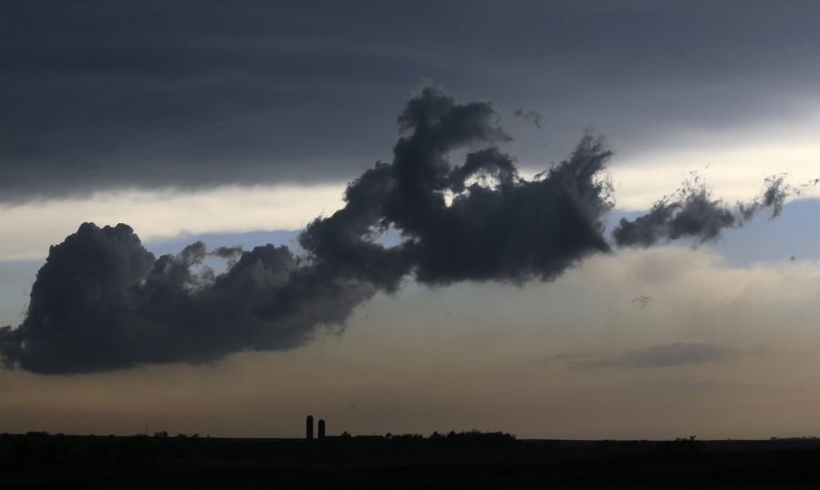 A low cloud moves over a farm near Gypsum, Kan., on Tuesday. Thunderstorms bearing hail as big as grapefruit and winds approaching hurricane strength lashed portions of the Great Plains on Tuesday. The area is expecting severe weather.