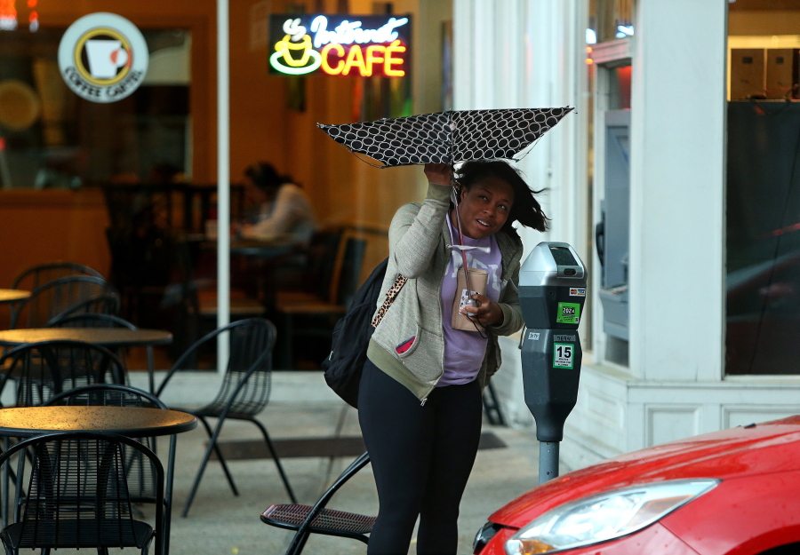Nicole Brown of Hazelwood tries to save her umbrella that succumbed to high winds on Tuesday, April 26, 2016, in St. Louis, Mo., as rain from an afternoon storm began to fall. &quot;I didn&#039;t know it was gonna rain like this,&quot; she said. (Christian Gooden/St.