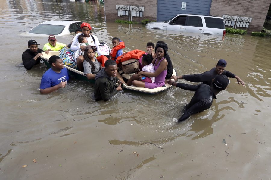 Residents are helped to evacuate an apartment complex surrounded by floodwaters Monday in Houston. Storms have dumped more than a foot of rain in the Houston area, flooding dozens of neighborhoods, closing city offices and shutting down public transit. (David J.