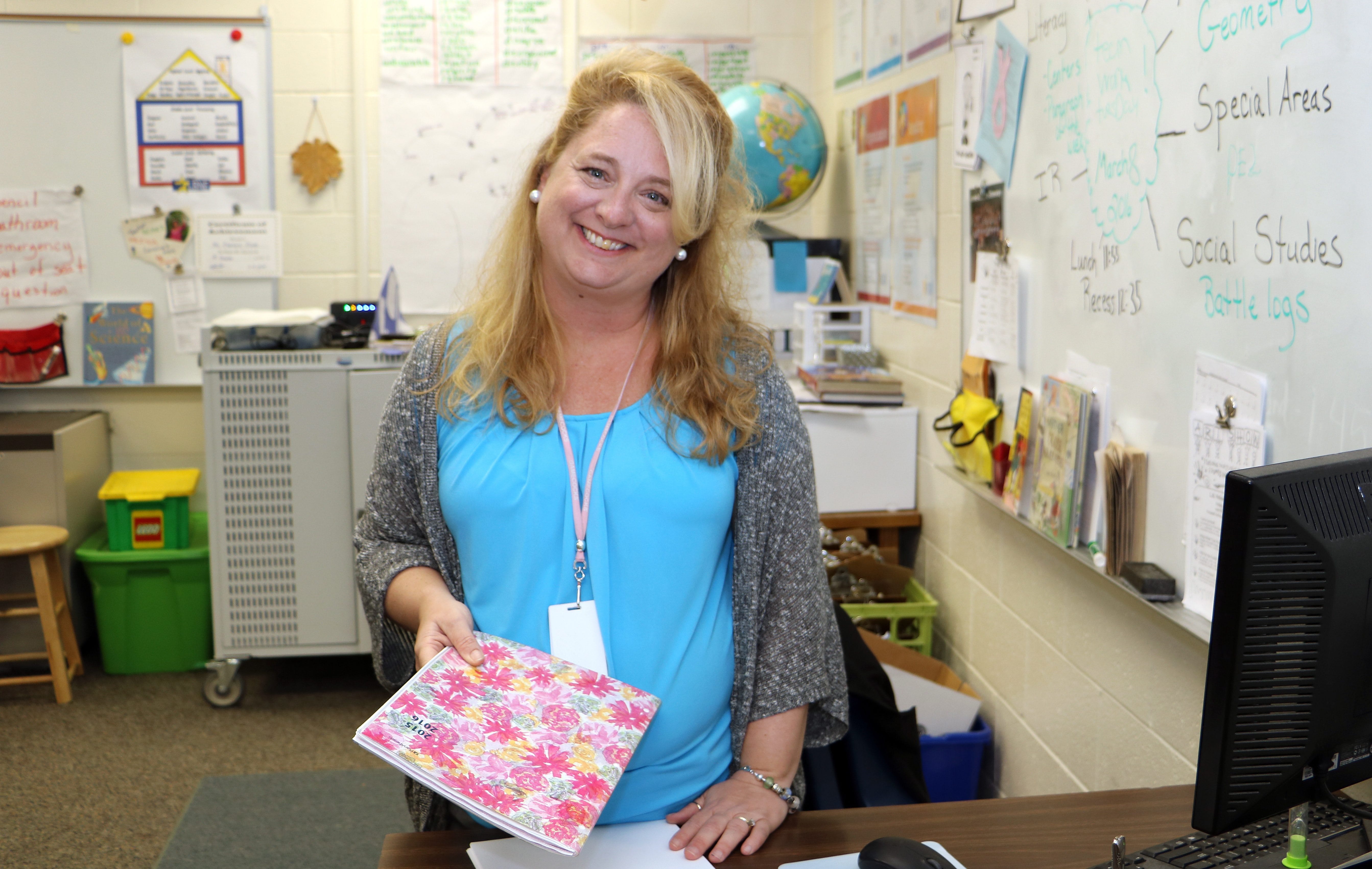 In this March 8 2016 photo, fourth-grade teacher Lori Clarke prepares for her students at Lonnie B. Nelson Elementary in Richland School District 2 in suburban Columbia, S.C. South Carolina's Career Changers loan-forgiveness program nearly covered the cost of Clarke's master's degree in education from the University of South Carolina. After graduating, $45,000 worth of loans were erased over three years of teaching at a high-poverty school in the Columbia area. She now works in a nearby school district. (AP Photo/Seanna M.