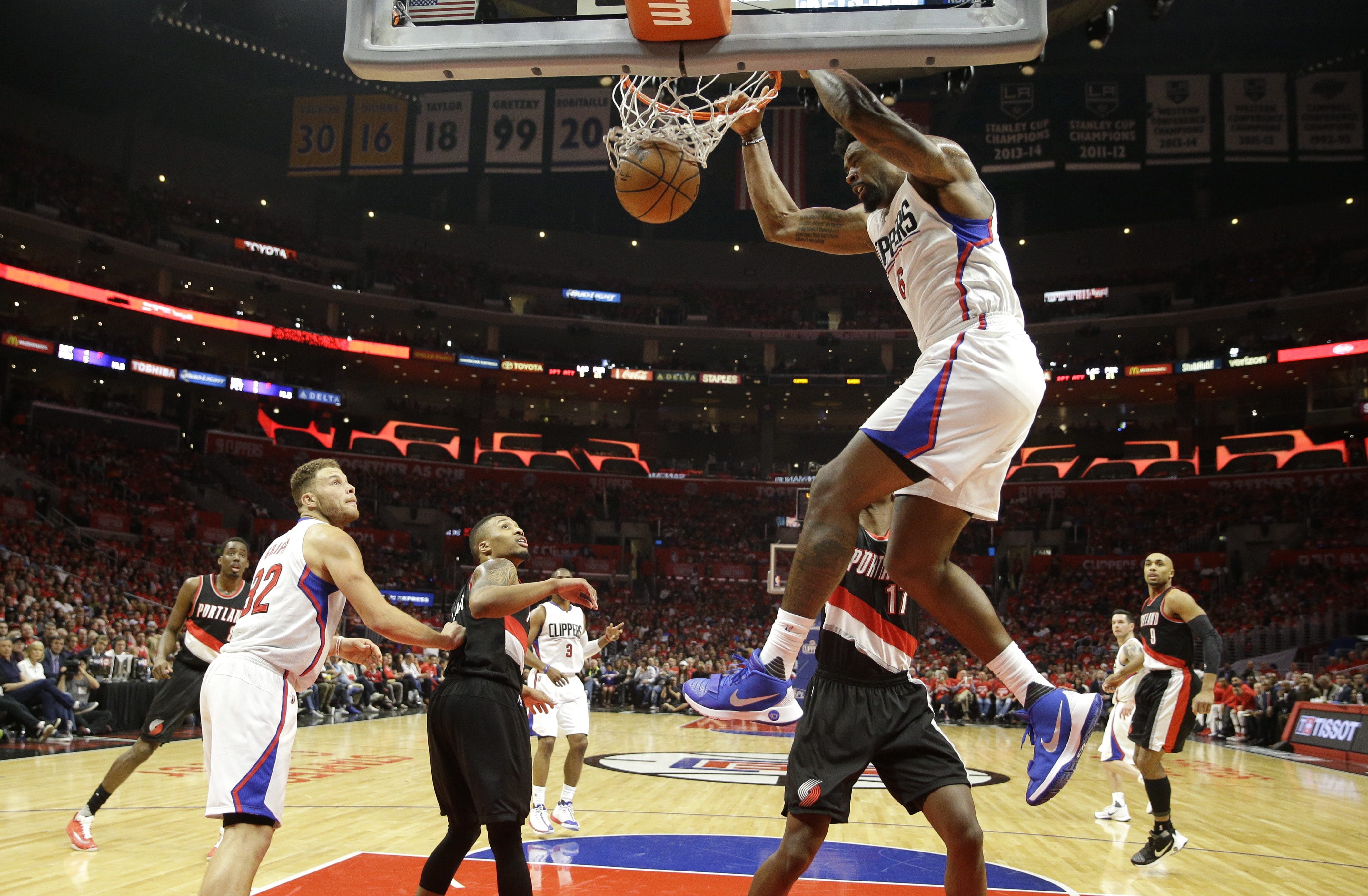 Los Angeles Clippers' DeAndre Jordan, top, dunks as teammate Blake Griffin, left, and Portland Trail Blazers' Damian Lillard watch in the second half in Game 1 of a first-round NBA basketball playoff series, on Sunday, April 17, 2016, in Los Angeles. The Clippers won 115-95. (AP Photo/Jae C.