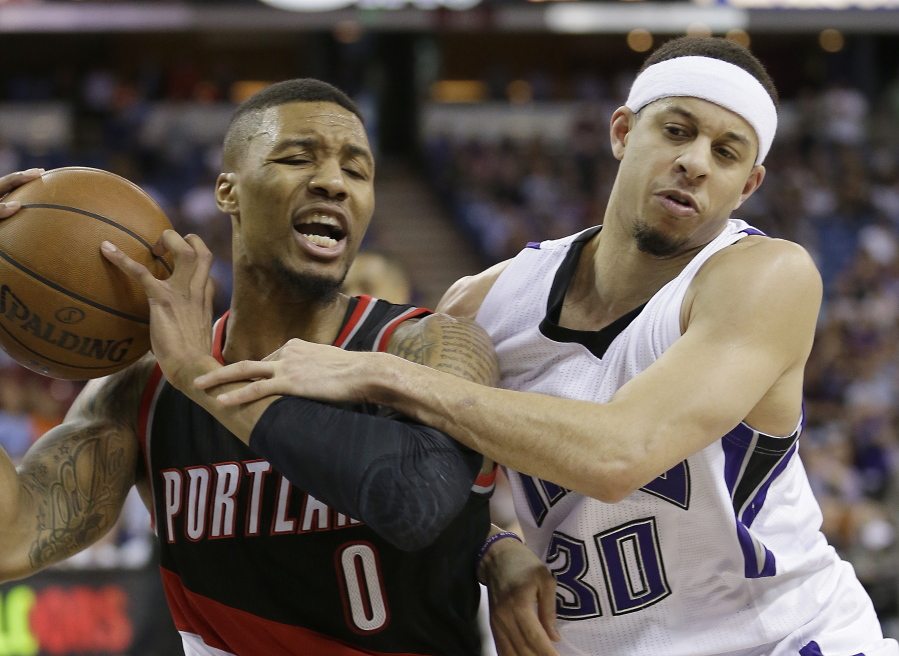Portland Trail Blazers guard Damian Lillard left, is fouled by Sacramento Kings guard Seth Curry during the second half of an NBA basketball game Tuesday, April 5, 2016, in Sacramento, Calif. The Trail Blazers won 115-107.