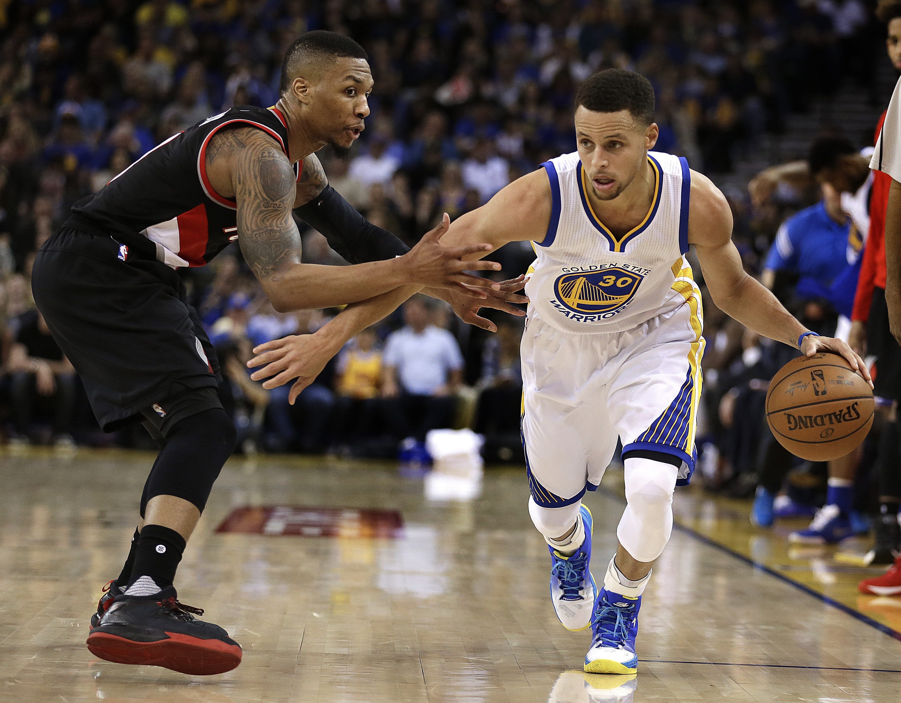 Golden State Warriors' Stephen Curry, right, drives the ball past Portland Trail Blazers' Damian Lillard during the second half of an NBA basketball game Sunday, April 3, 2016, in Oakland, Calif.