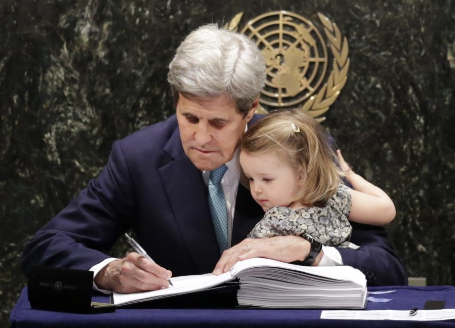 U.S. Secretary of State John Kerry holds his granddaughter, Isabel Dobbs-Higginson, as he signs the Paris Agreement on climate change Friday at U.N. headquarters.