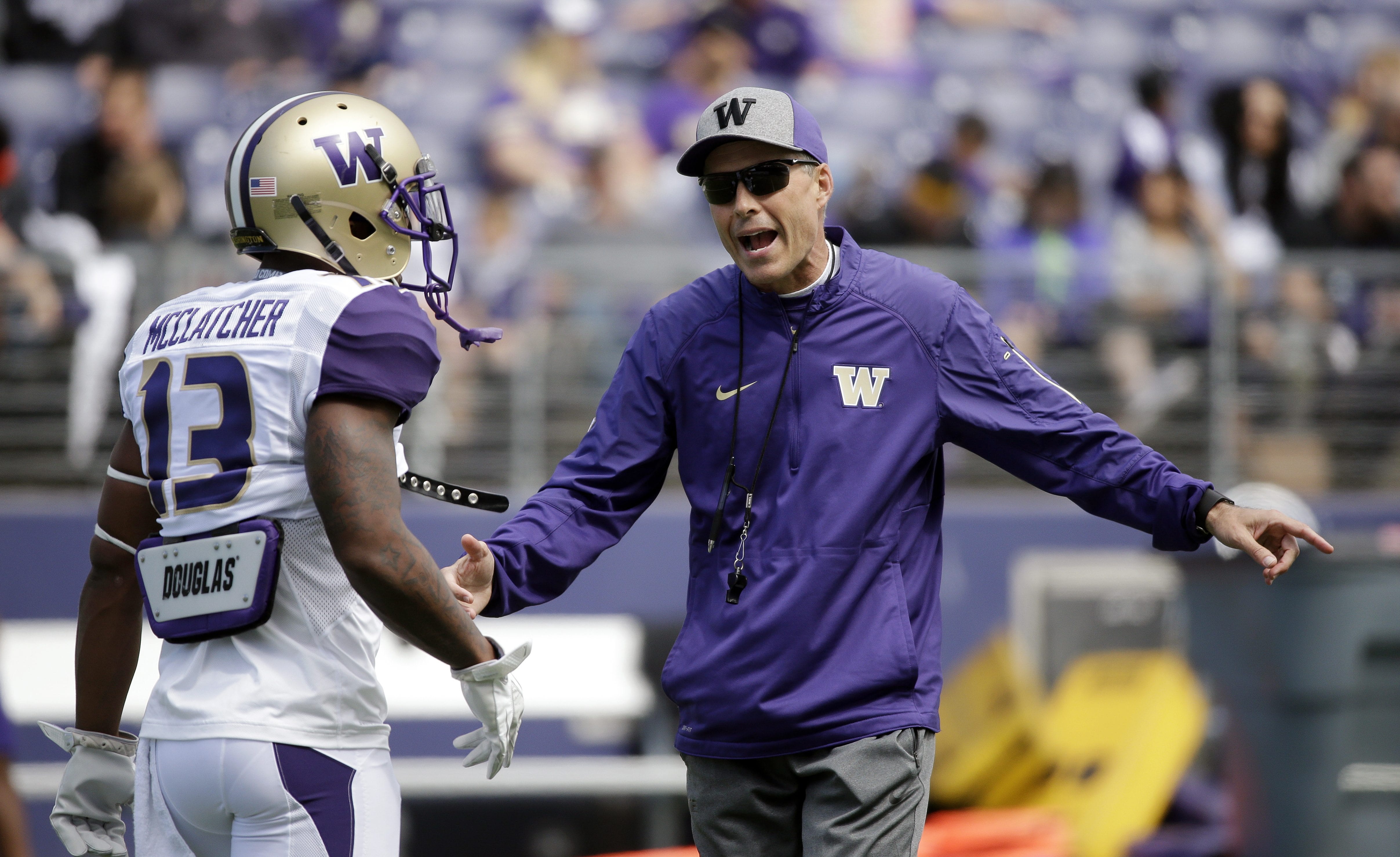 Washington head coach Chris Petersen, right, talks with Chico McClatcher at the team's annual spring preview football event Saturday, April 23, 2016, in Seattle.