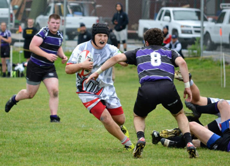 Union vice captain Jake Burchett, center, looks to elude a Portland Pumas defender during the Varsity Premiership Cup final Saturday at Delta Park.