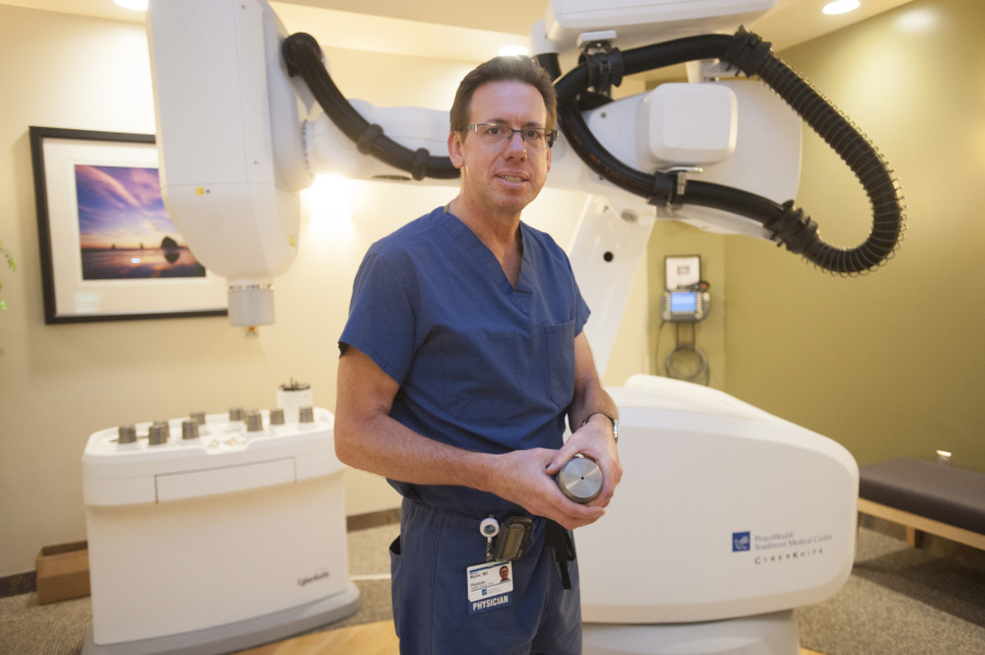 Dr. Michael Myers, a radiation oncologist at PeaceHealth Southwest Medical Center, holds a tungsten collimator with which the &quot;cyberknife&quot; machine in the background &quot;paints&quot; cancerous areas with radiation. Myers has treated 16 prostate cancer patients with the cyberknife, all of whom went into remission with no recurrences.