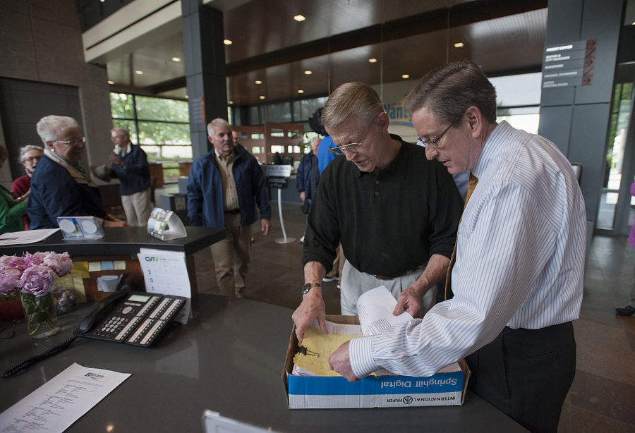 Former Vancouver Mayor Bruce Hagensen, second from right, and City Clerk Lloyd Tyler, right, look through a box of signed petitions Thursday at City Hall. The petition seeks to let voters decide whether the Vancouver City Council&#039;s pay hikes should be rescinded.