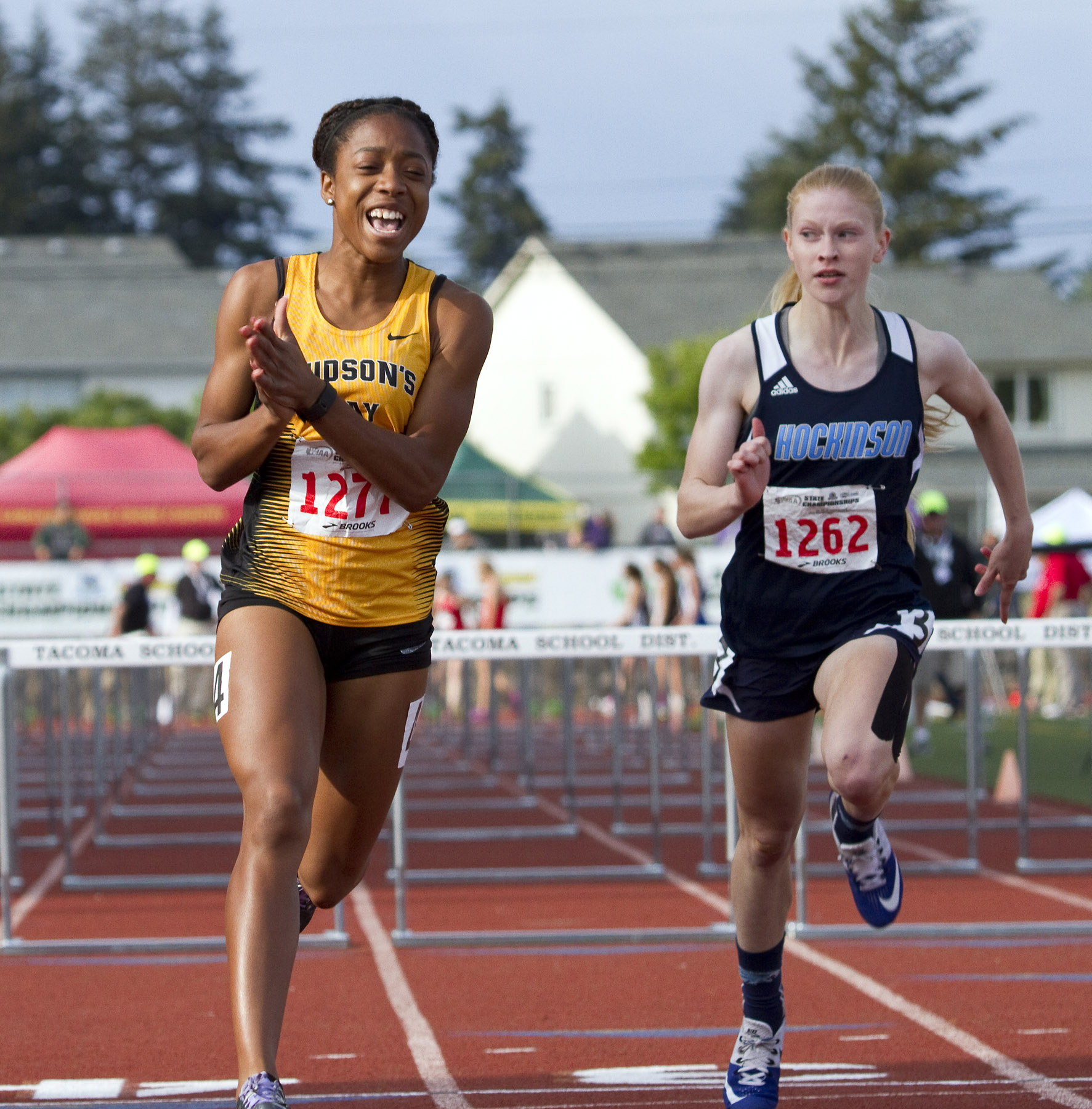 Hudson's Bay's Erykah Weems, left, celebrates as she crosses the finish line in 1st place during the 2A Girls 100 Meter Hurdles event at the State Track and Field Championships on May 27, 2016, in Tacoma, Wash.  Hockinson's Alyssa Chapin is on the right.