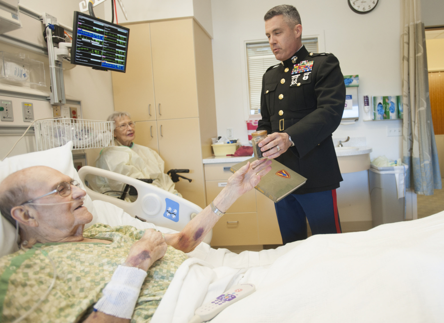 Ed Tice, left, a World War II Marine veteran, accepts a container of Iwo Jima beach sand Tuesday from Lt. Col. Brad Aiello at Legacy Salmon Creek Medical Center. Tice died Friday afternoon.