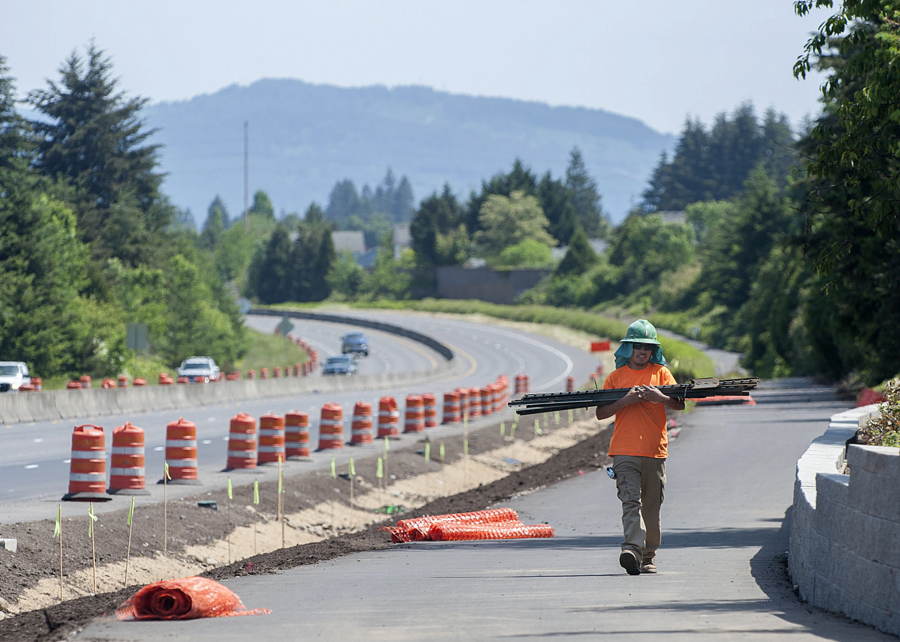Jonathan Anaya of Tapani Inc. removes fencing from along Padden Parkway near the intersection with Northeast 94th Avenue on Friday afternoon. Improvements along Padden Parkway and across Clark County have been identified as necessary to fully support the county&#039;s Comprehensive Growth Management Plan update.