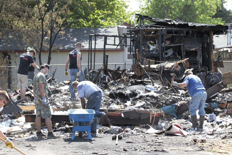 Volunteers rally to help Lisa Berck, whose home was destroyed in a fire May 1, clean up the remains and help her avoid a big fine.