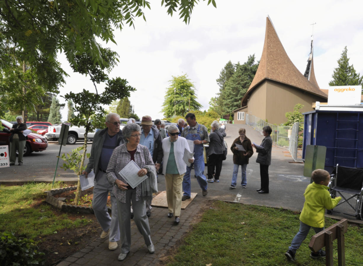 Members of the First Congregational United Church of Christ arrive for the Sunday morning service under a tented area on church grounds. Their church was damaged in a suspected arson Wednesday.