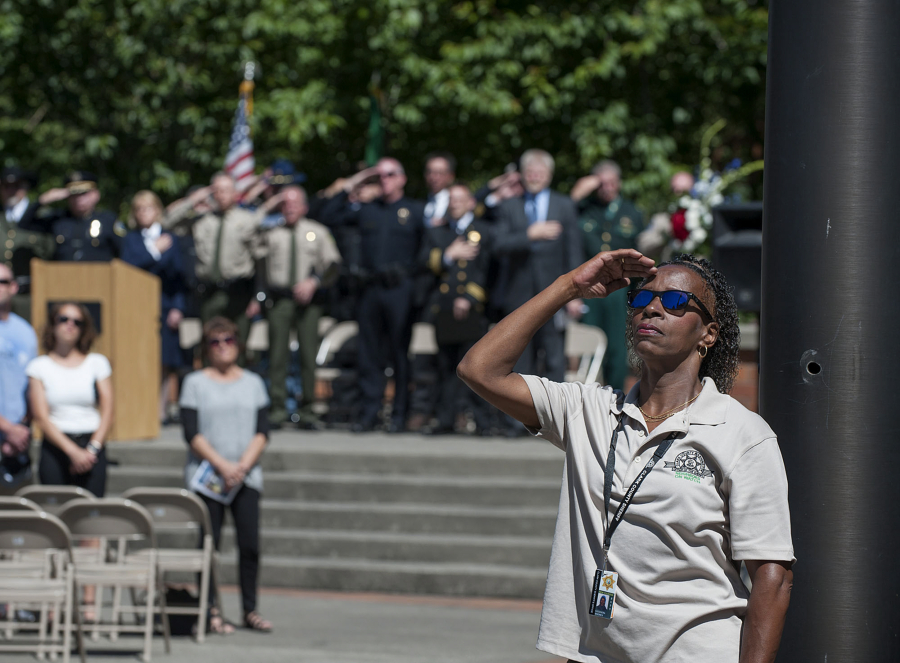 Clark County Sheriff's Office volunteer Cassandra Kendrick joins the crowd Thursday as the American flag is raised and then lowered to half-staff as part of the Law Enforcement Memorial Ceremony. The annual event honors officers, deputies and troopers who have died in the line of duty.