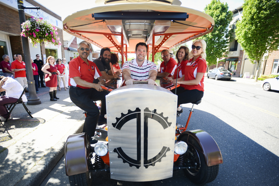 Mayor Tim Leavitt sits in the driver&#039;s seat of the Couve Cycle, a pedal-powered party cycle, during the Greater Vancouver Chamber of Commerce&#039;s Small Business Crawl in Uptown Village on Wednesday. Owner Michael Palensky sits on the left in the second seat from the front.