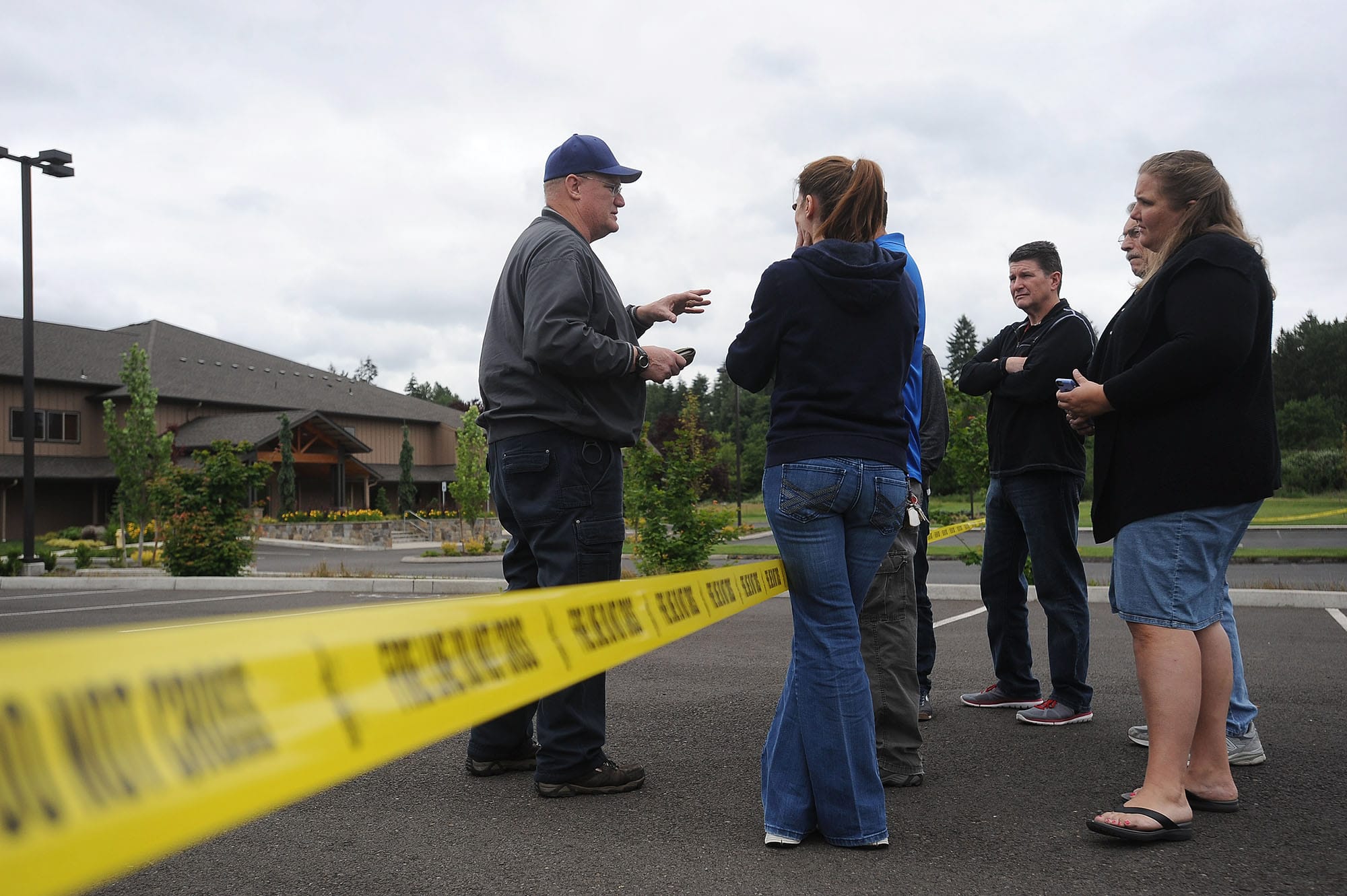 Deputy Fire Marshal Dan Young, left, briefs congregants of the Liberty Bible Church of the Nazarene in Salmon Creek on Thursday. The suspected arson was the second on a church in as many days.