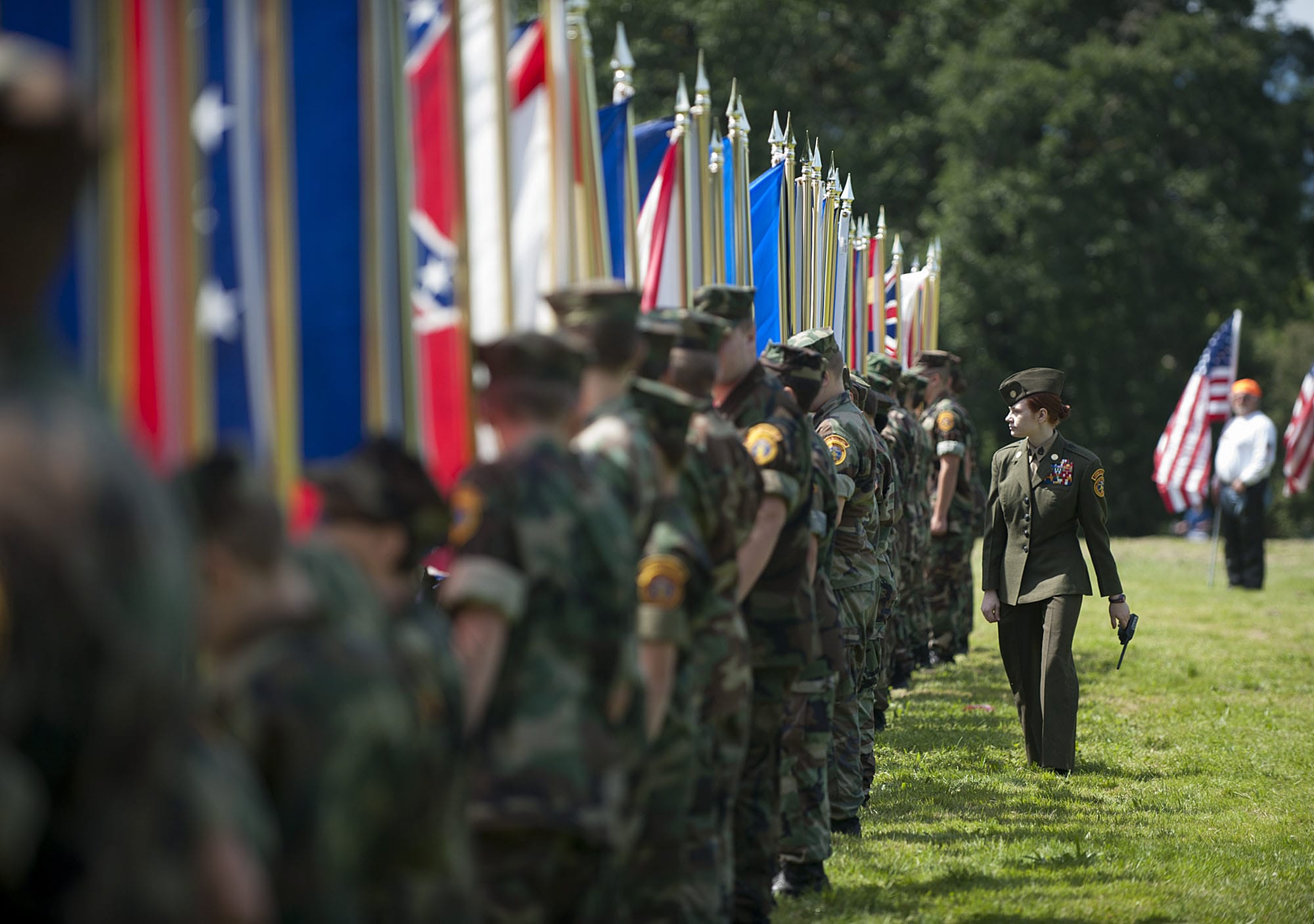 Emily Brinton, 16, of the Lewis &amp; Clark Young Marines walks past the flags of each state before the start of the Memorial Day service Monday morning at Fort Vancouver National Historic Site.