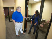 State Farm agent Michael Harris, left, talks with office representative Eliza Fausto at his office in Salmon Creek.