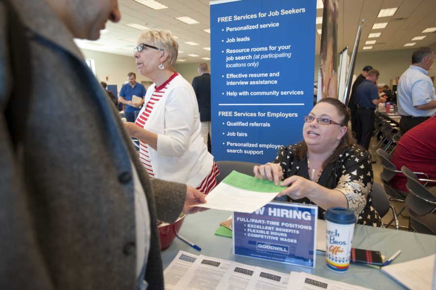 Shawn Webster of Goodwill Job Connection hands out an application at a jobs fair at the Armed Forces Reserve Center in Vancouver on Monday morning. It was the sixth jobs fair hosted by U.S. Rep. Jaime Herrera Beutler and featured 50 employers and more than 350 job hunters.