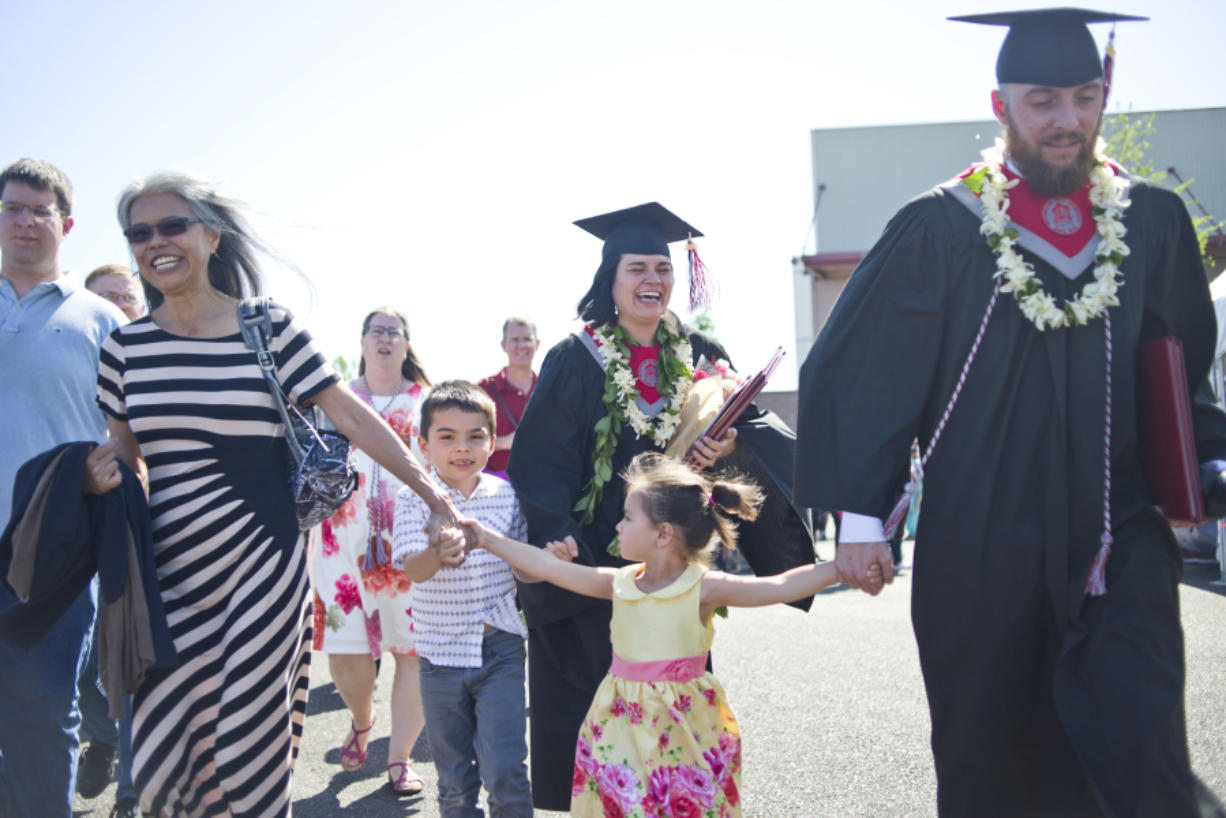 Jonas and Caitlin Calsbeek walk with their children, Jacob, 4, and Lily, 3, and Caitlin&#039;s mother, Brenda Tokuoa, to their car after the 2016 Washington State University Vancouver commencement ceremony at the Sunlight Supply Amphitheater on Saturday. The Calsbeeks, who are both Navy veterans, earned two degrees each.