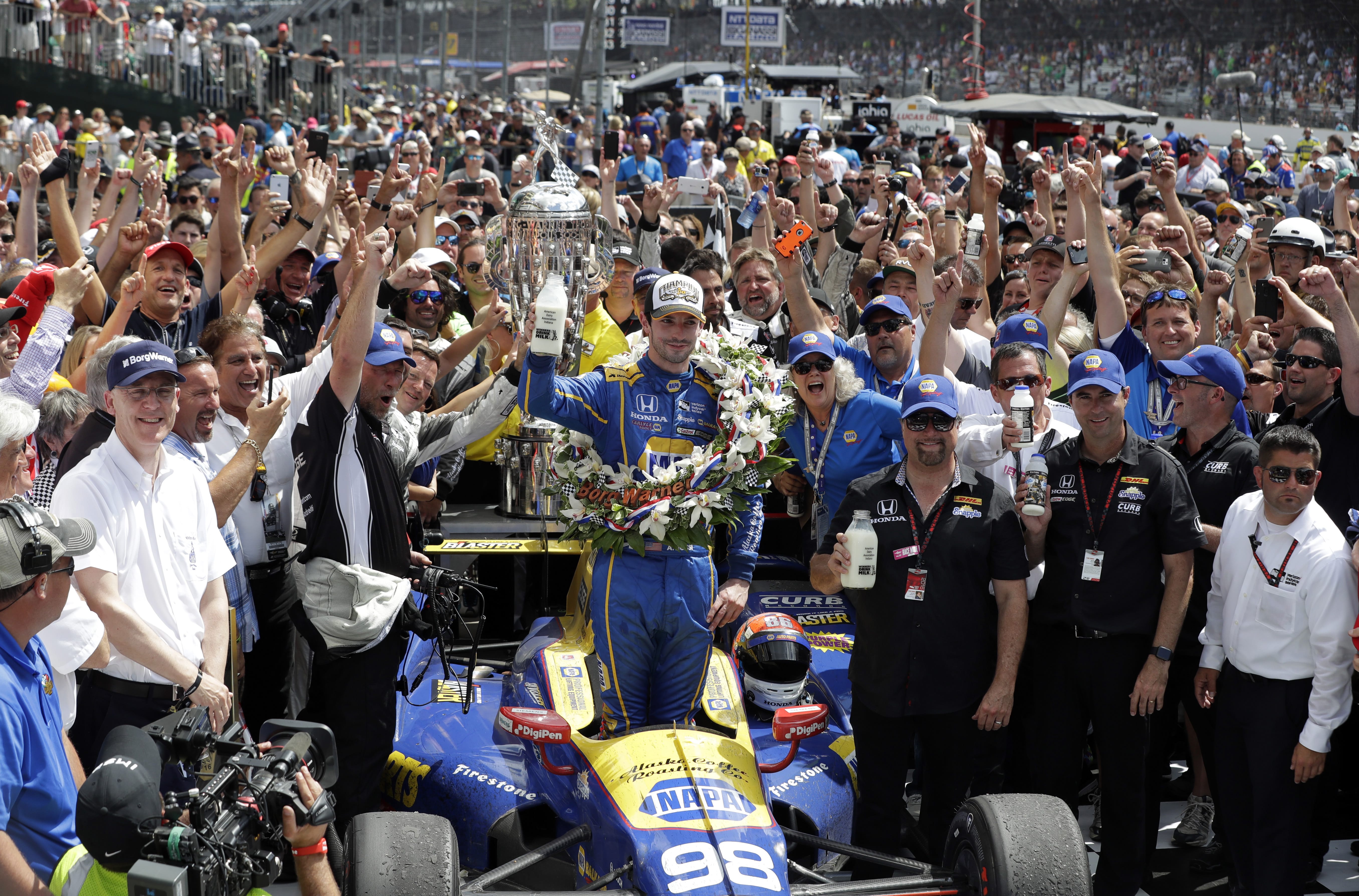 Alexander Rossi, center, celebrates after winning the 100th running of the Indianapolis 500 auto race at Indianapolis Motor Speedway in Indianapolis, Sunday, May 29, 2016.