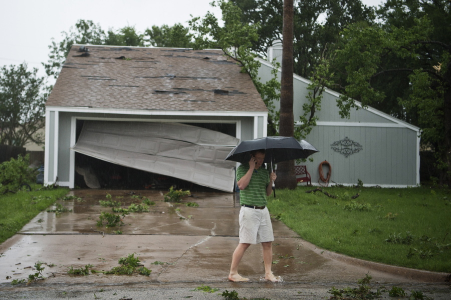 Bryan resident Alfred Smith calls family Thursday while walking in front of his neighbor&#039;s home after a tornado touched down in the Wheeler Ridge neighborhood in Bryan, Texas.