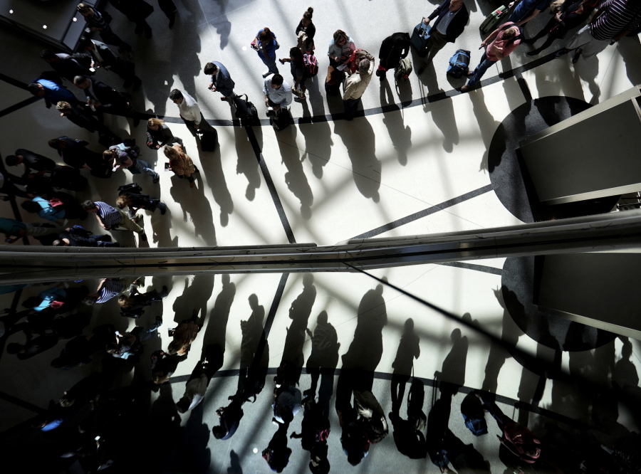 Passengers are reflected in glass as they line up to go through a security checkpoint in March at Hartsfield-Jackson Atlanta International Airport in Atlanta.