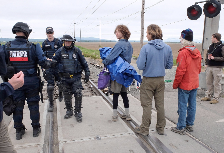 Authorities wrap up clearing the railroad tracks of protesters Sunday west of Burlington. Dozens of climate activists were arrested Sunday morning after a two-day shutdown. About 150 people spent the night in tents and sleeping bags on the tracks near two refineries in Northwest Washington, according to BNSF Railway spokesman Gus Melonas.
