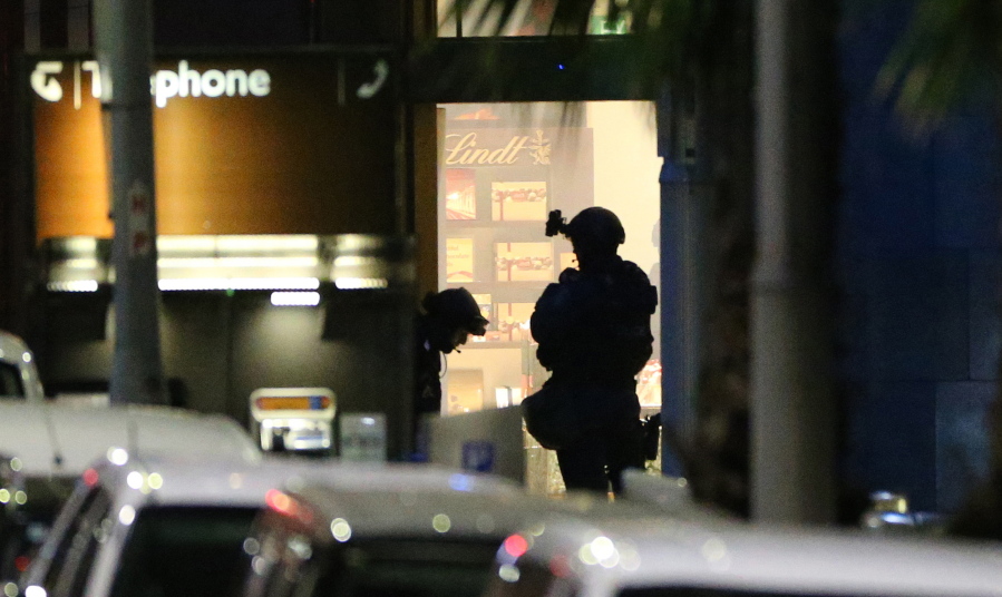 Armed tactical response officers stand ready to enter the Lindt cafe during a siege in the central business district of Sydney, Australia.