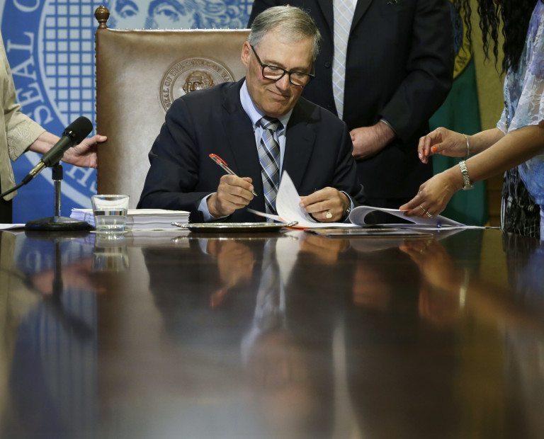 Washington Gov. Jay Inslee is reflected in his conference room table April 18 at the Capitol in Olympia. (AP Photo/Ted S.