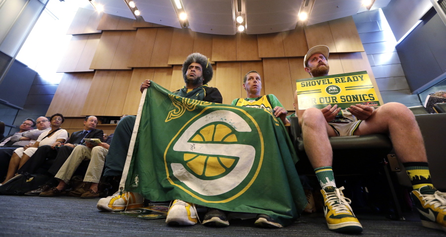 Fans of the defunct Seattle SuperSonics team, from left, Kris &quot;Sonics Guy&quot; Brannon, Kenneth Knutsen and Andrew Wergeland-Rammage, look on during testimony before the Seattle City Council Monday in Seattle. The council voted against vacating a stretch of road where an investor hoped to eventually build an arena that could house an NBA and NHL team.