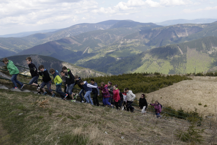 In this photo taken on Wednesday, May 11, 2016, tourists walk towards an artificial lake atop a mountain near the village of Loucna nad Desnou, Czech Republic. A pumped storage hydro plant featuring an artificial lake atop a mountain has turned into a top tourist site in the Czech Republic that?s about to welcome its millionth visitor.