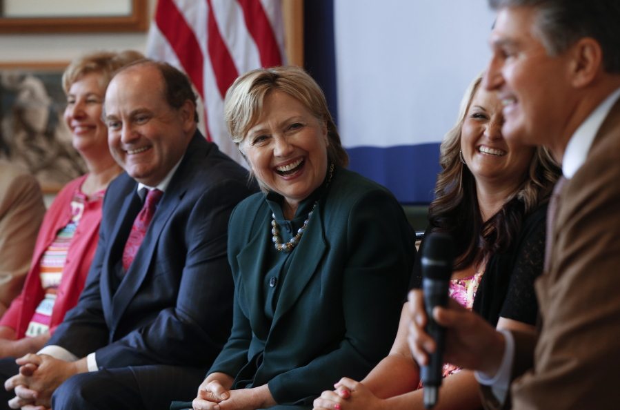 Democratic presidential candidate Hillary Clinton laughs while listening to Sen. Joe Manchin, D-W. Va., right, during a campaign stop in Charleston, W. Va., on Tuesday.